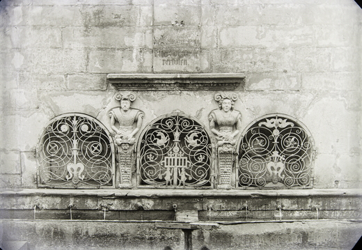Neunröhrenbrunnen - (Foto von 1915) Zwei Brunnenmännchen oberhalb der 9 Wasserröhren